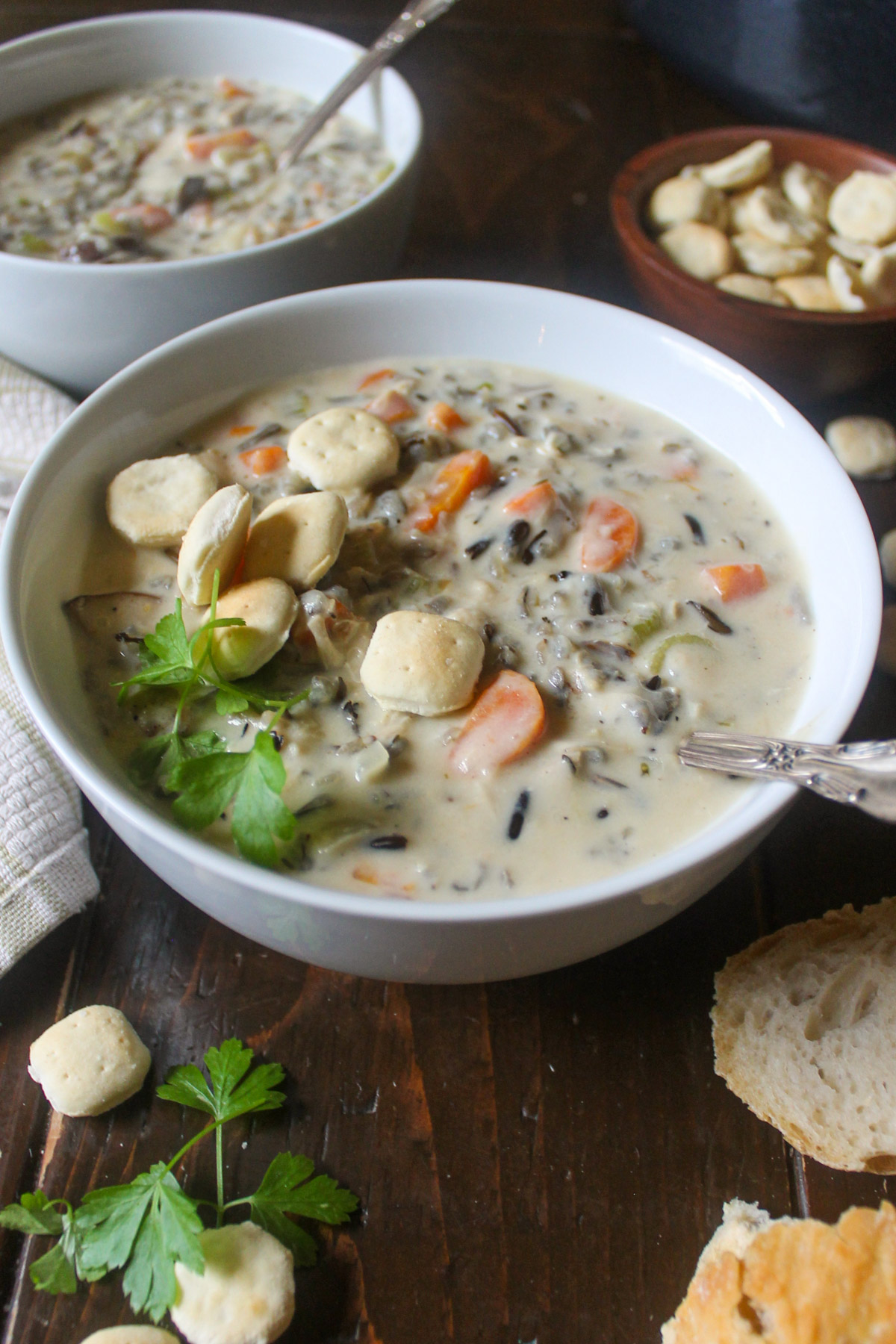 A white bowl of Minnesota chicken wild rice soup with crackers.