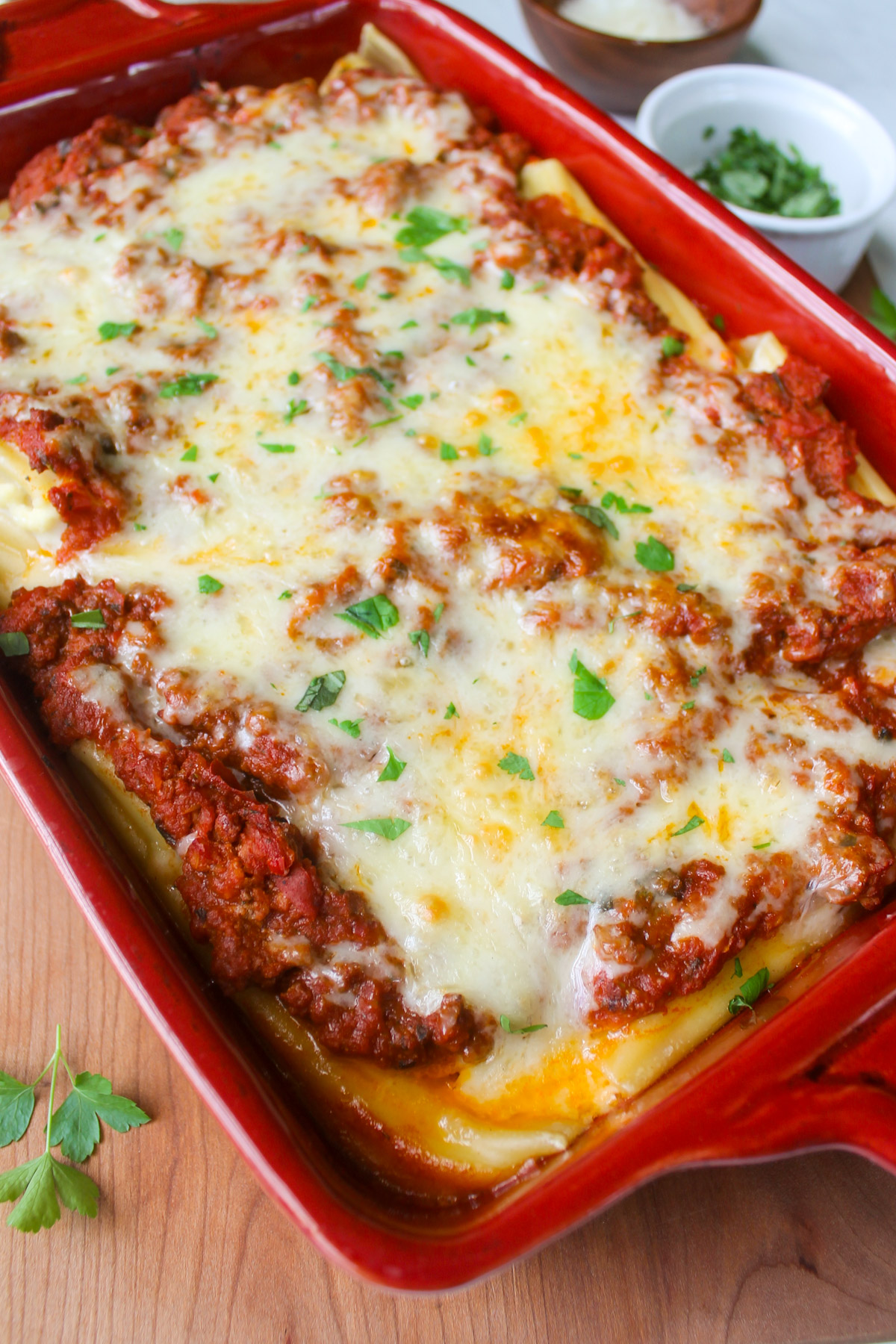A pan of baked manicotti topped with fresh herbs.