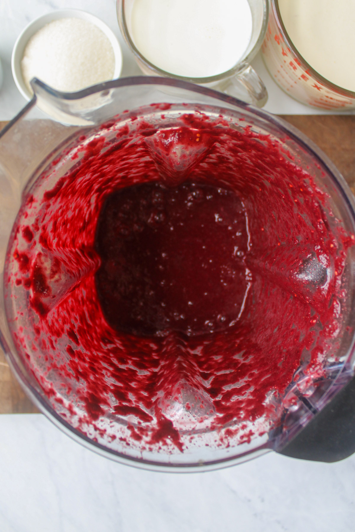 Dark red mulberries pureed in a blender.