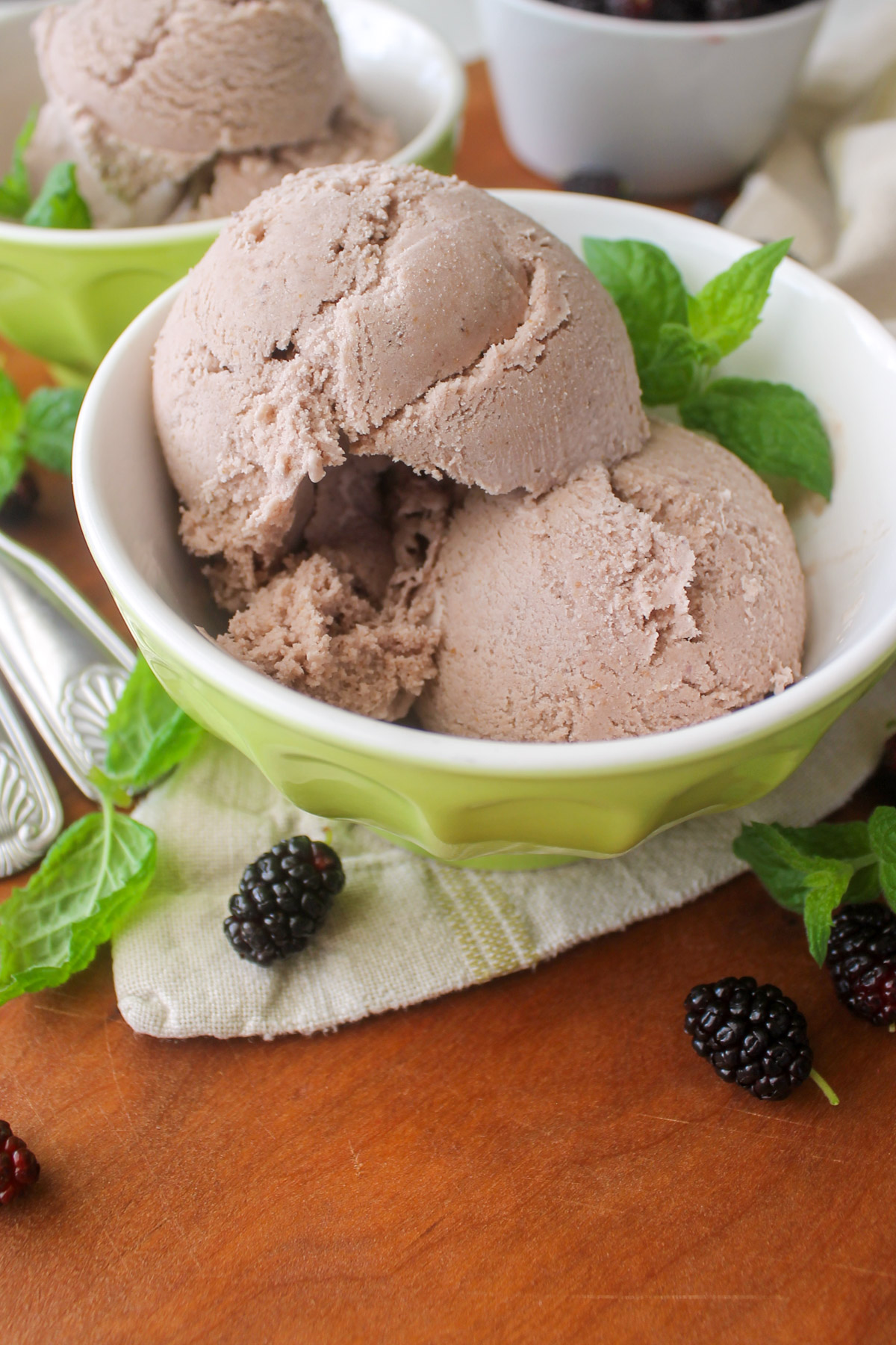 Two scoops of homemade mulberry ice cream in a bowl.