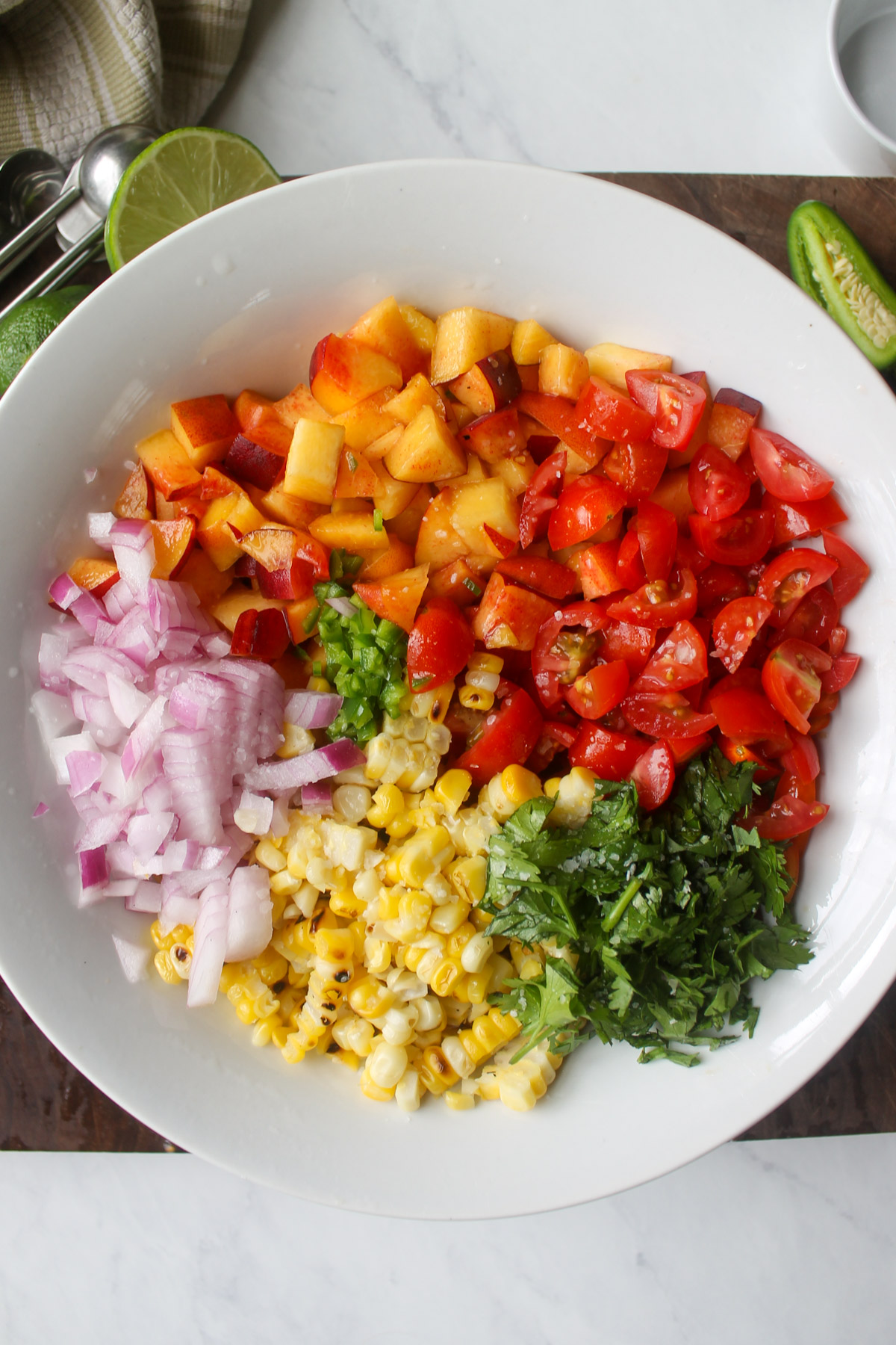 A bowl of ingredients for peach corn salsa.