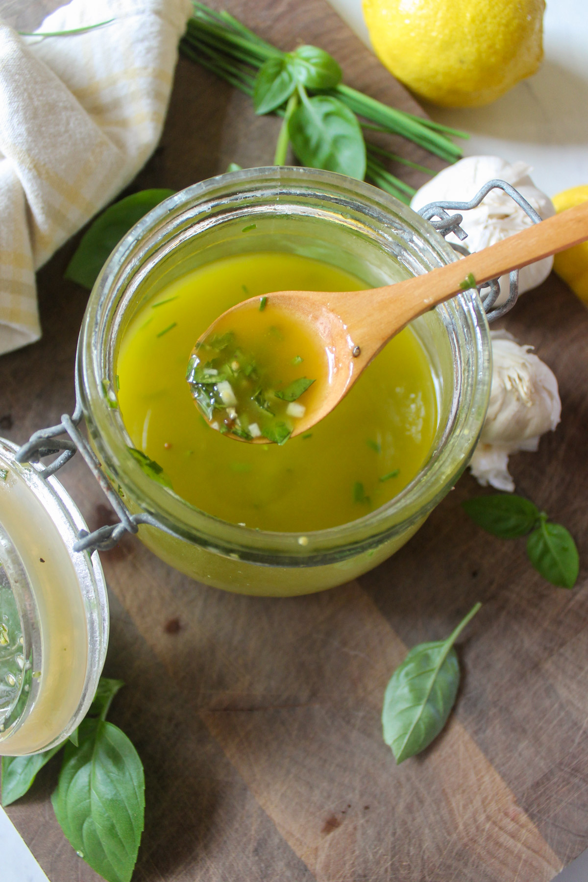 A wooden spoon dipped into Lemon Herb Vinaigrette Dressing.