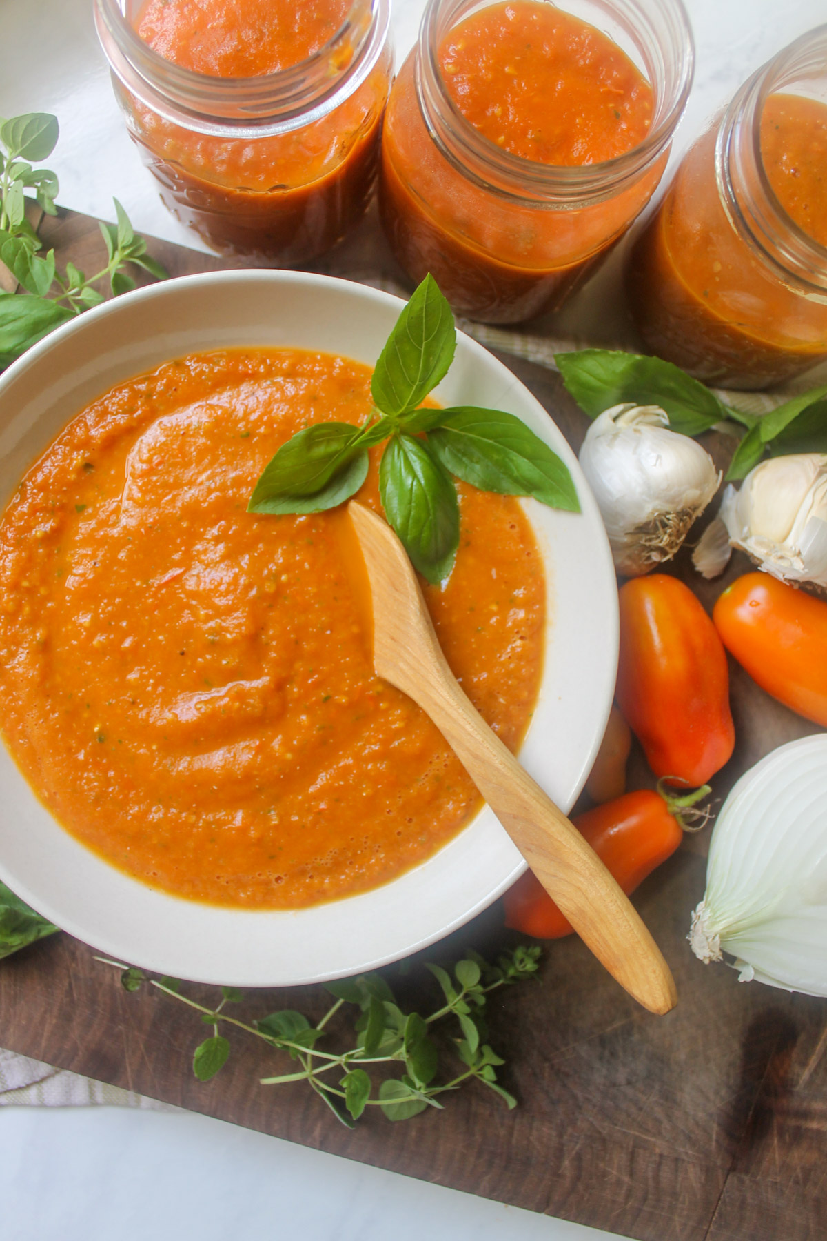 A bowl of roasted tomato pizza sauce with jars to freeze.