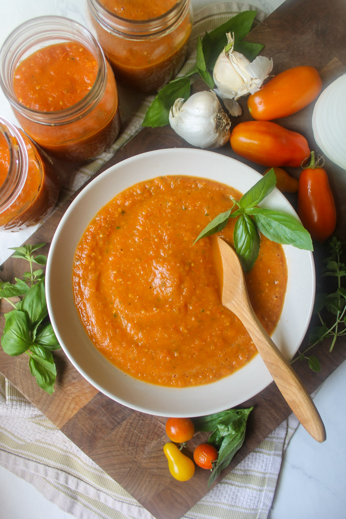 Pizza sauce in a bowl with 3 extra jars for the freezer.