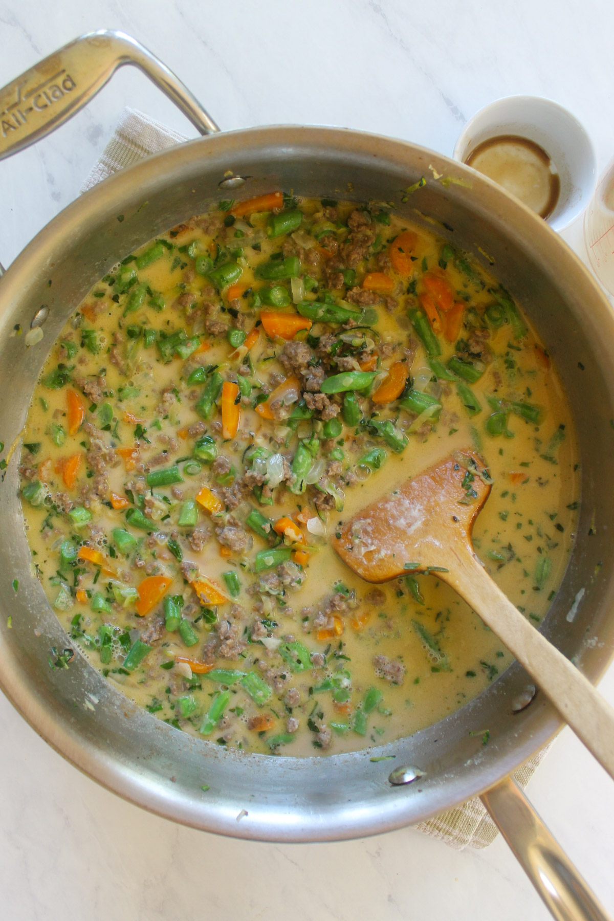 A skillet of beef and vegetables cooking in a cream sauce.