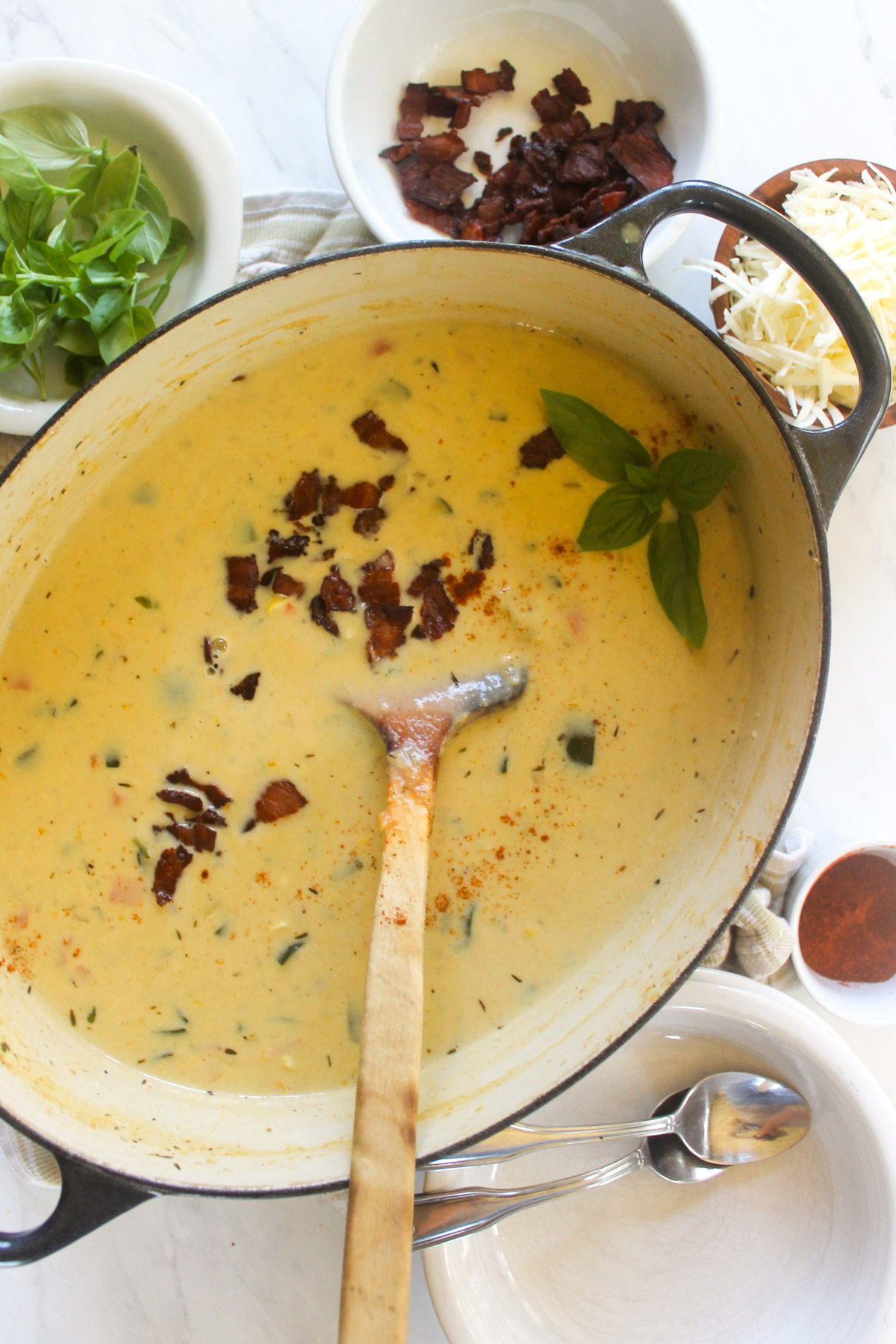 A soup pot of Zucchini Corn Chowder topped with crispy bacon.