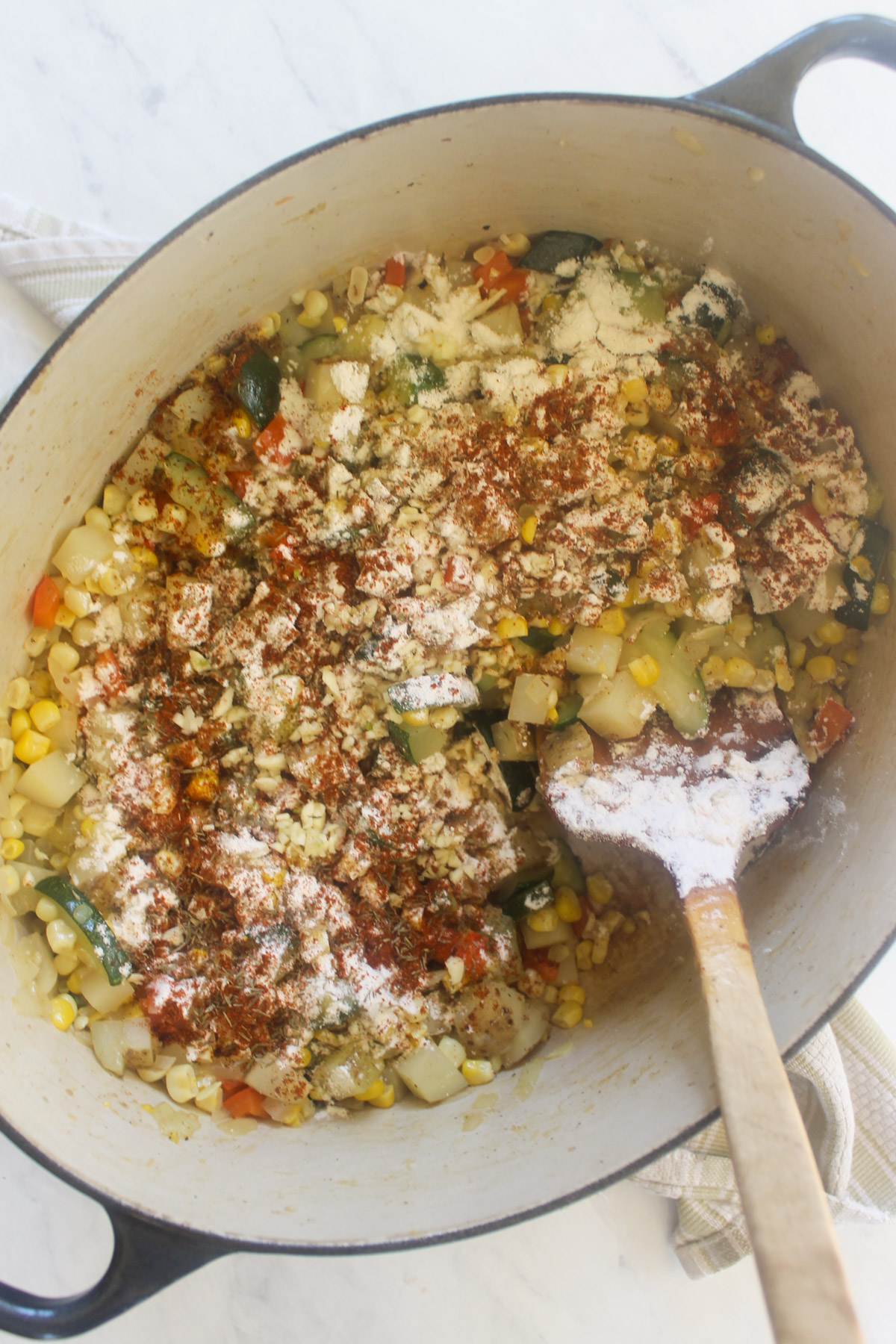 Adding flour and spices to zucchini corn chowder.