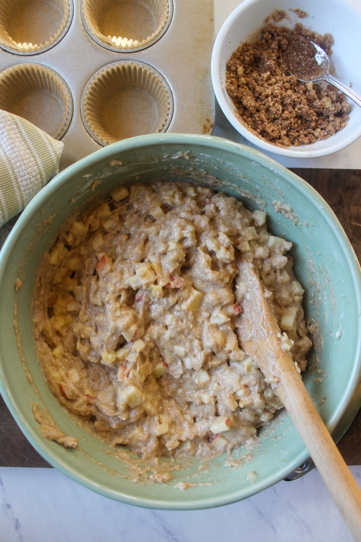 A green bowl of apple muffin batter.