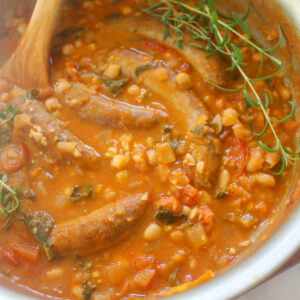 White bean cassoulet with sausage links in a tomato broth.