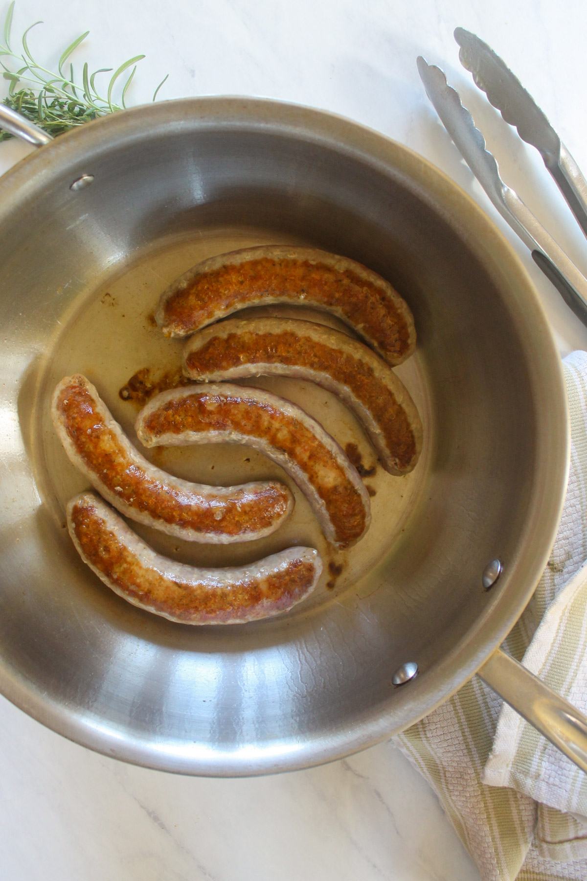 Seared Italian sausage links in a skillet.