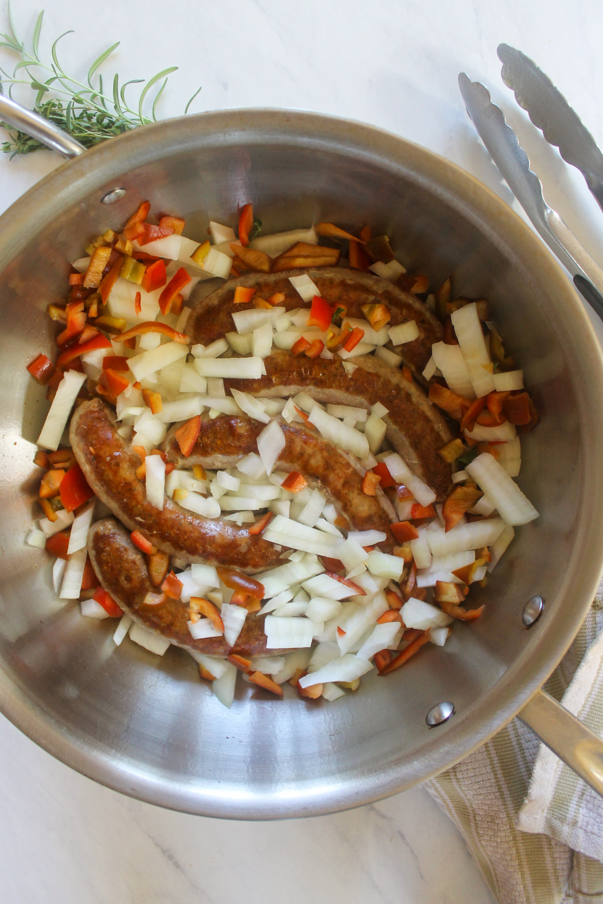 Seared sausage links with chopped onions and red bell pepper.