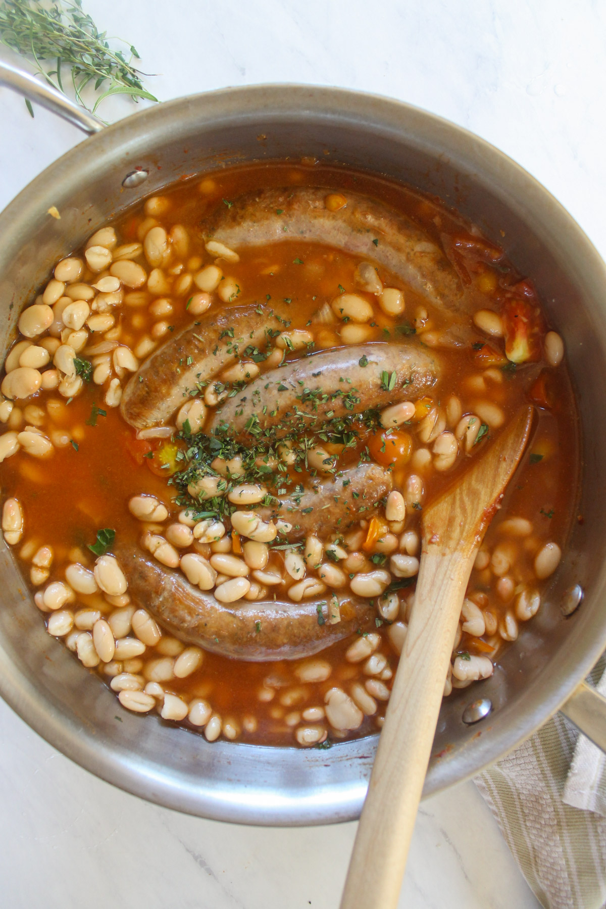 White beans and sausage links in a tomato broth.