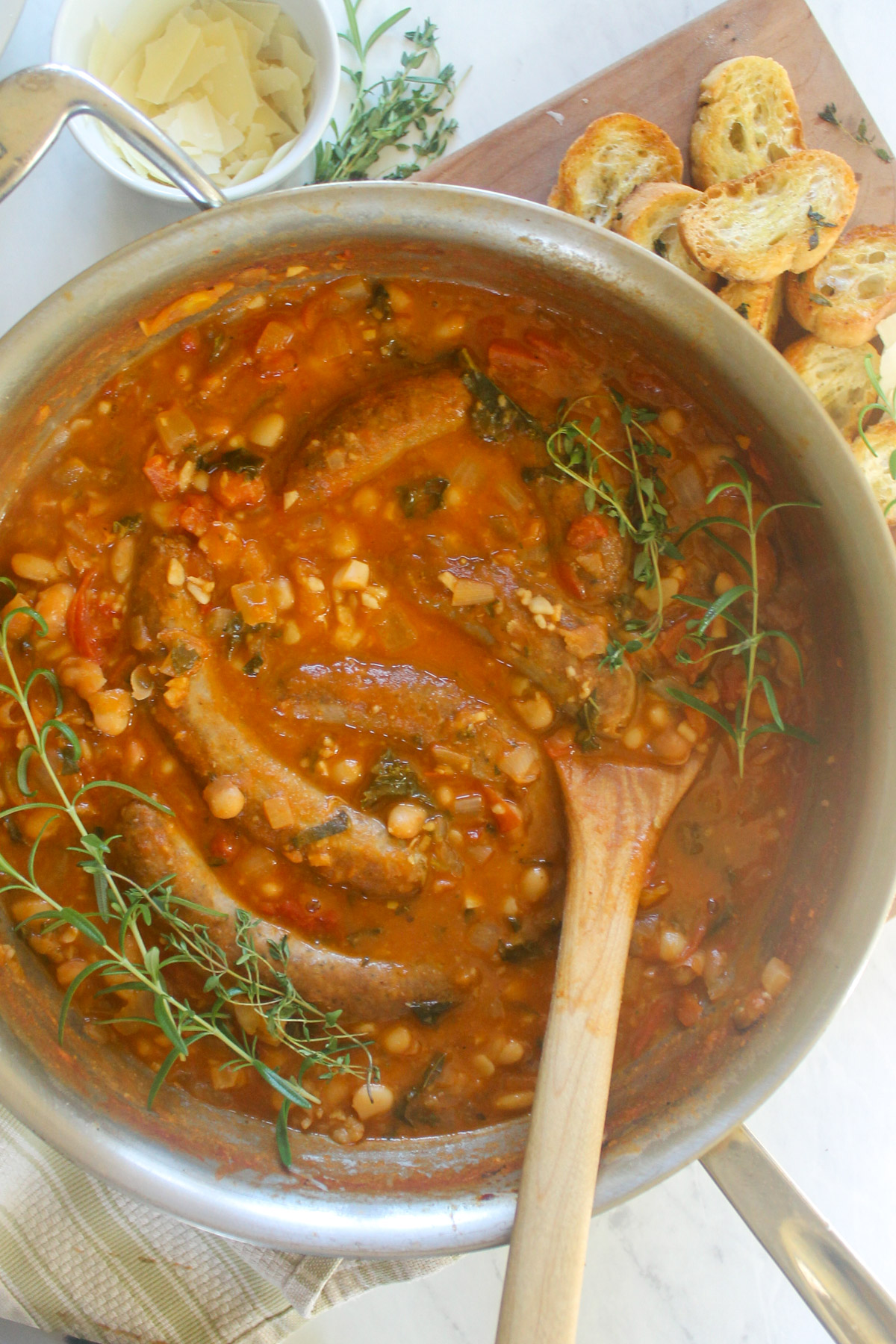 Skillet tomato white bean cassoulet with sausage and crusty bread.