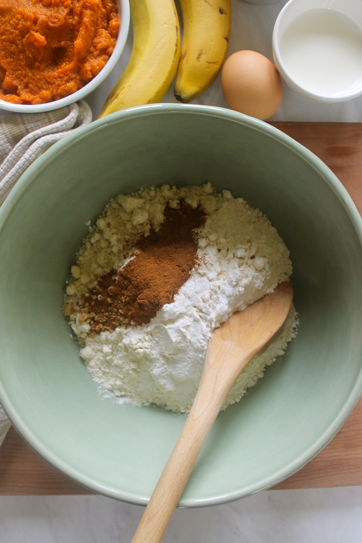 Dry baking ingredients in a green mixing bowl.