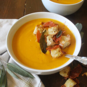 A bowl of orange pumpkin sweet potato soup.