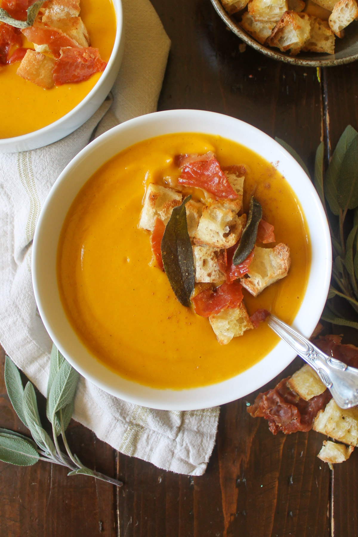 Bowls of creamy pumpkin soup with toppings.