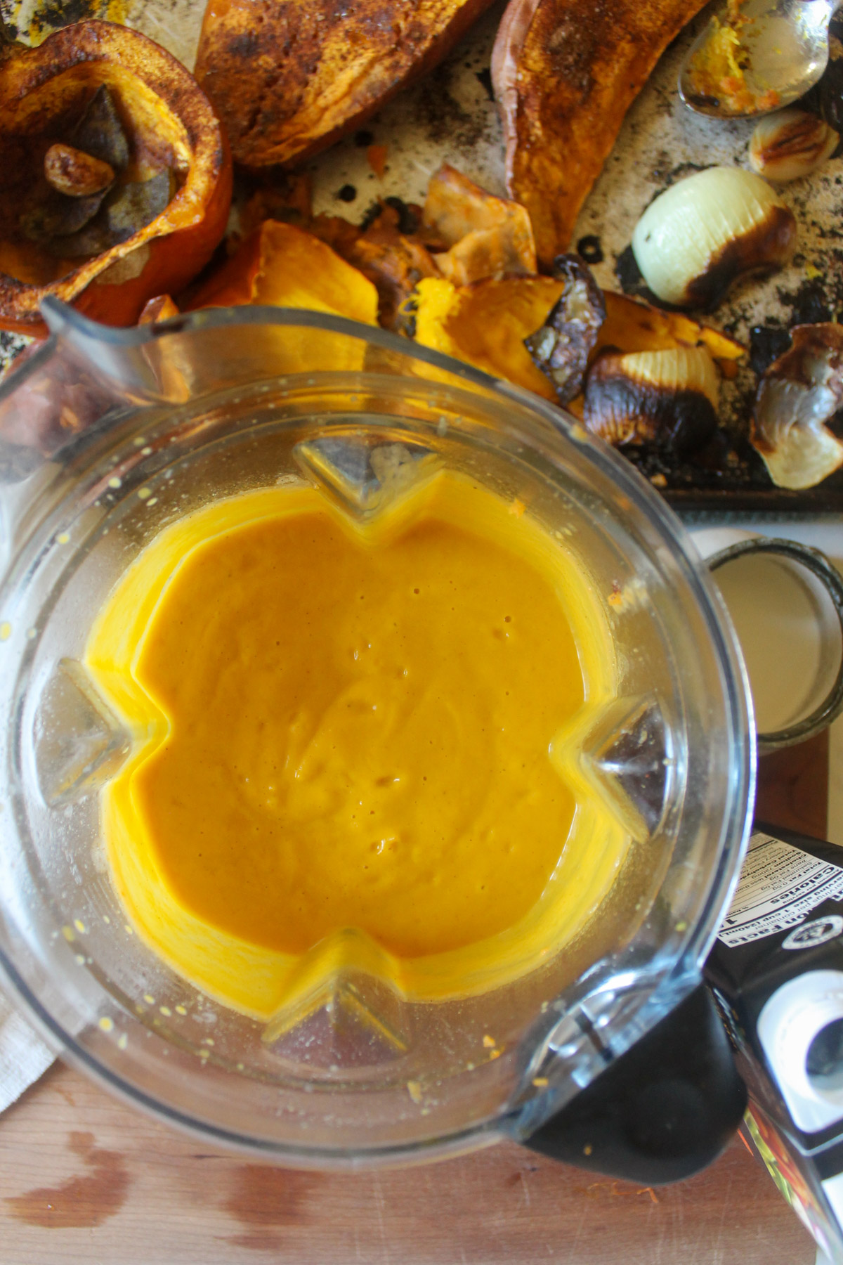 A blender with pureed pumpkin sweet potato soup.