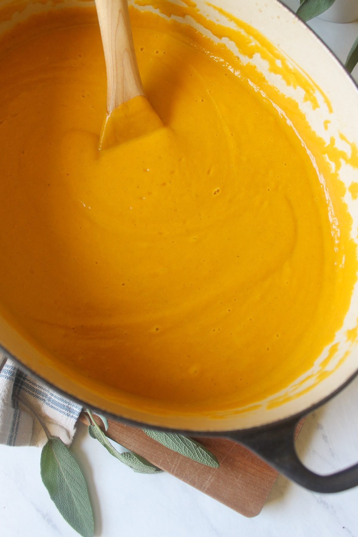 A pot of blended creamy pumpkin sweet potato soup.