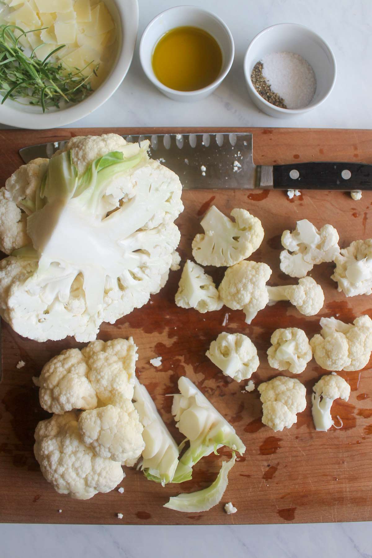 Cutting cauliflower into florets on a cutting board.