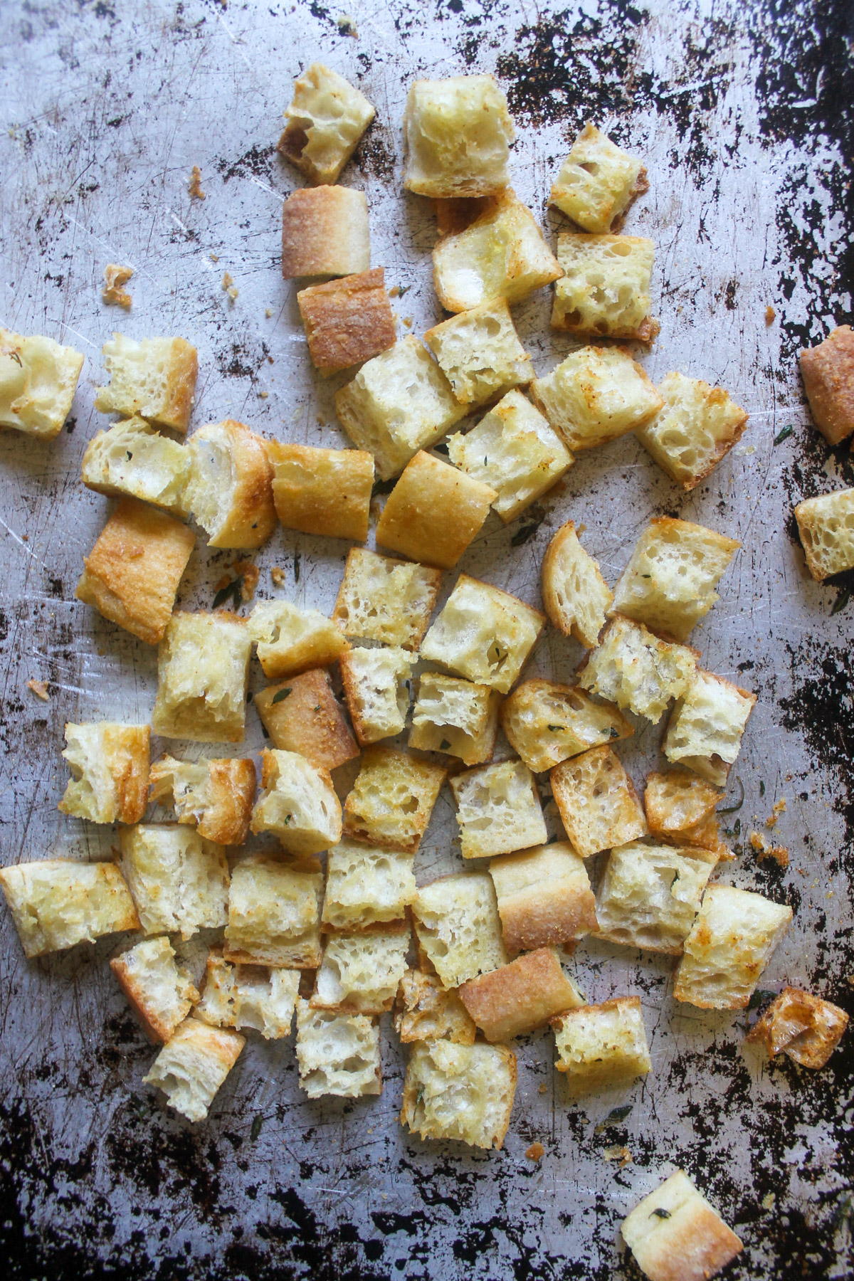 Baked homemade croutons on a sheet pan.