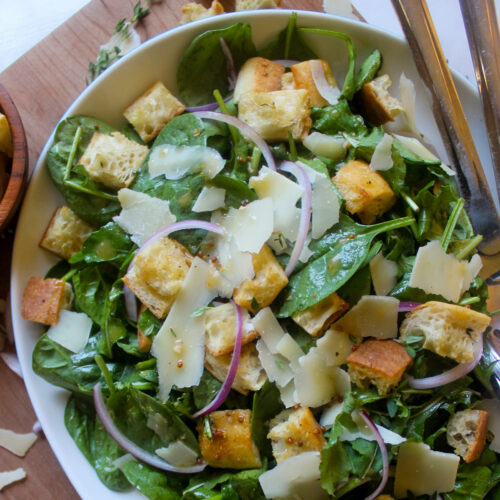 A platter of arugula spinach salad with homemade croutons.