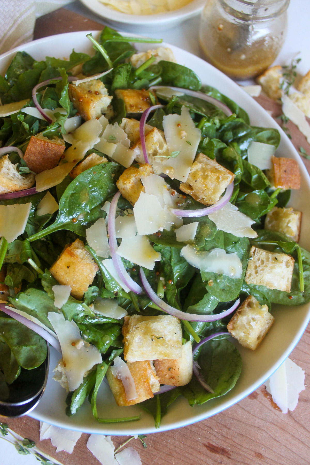 Spinach arugula salad with croutons and Parmesan cheese shavings.