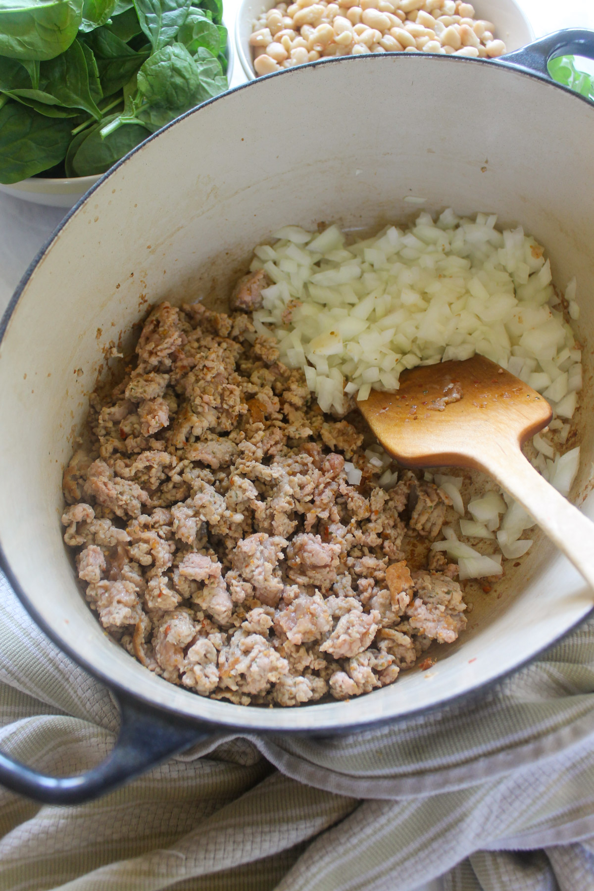 Browning sausage and onions in a soup pot.