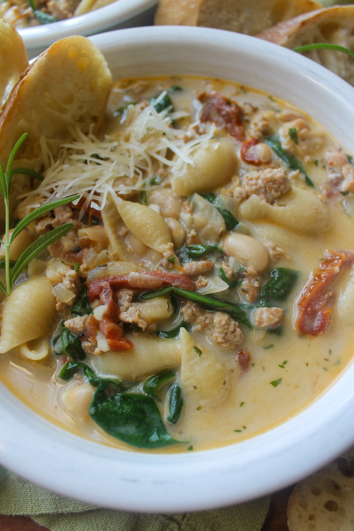 A bowl of creamy Tuscan soup with spinach and white beans.