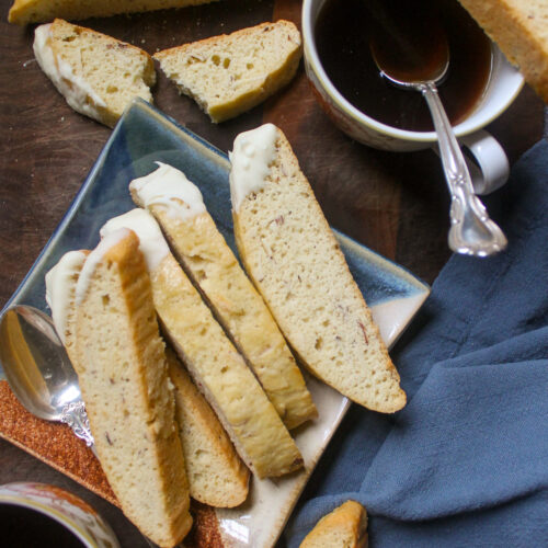 White chocolate dipped biscotti with cups of coffee.