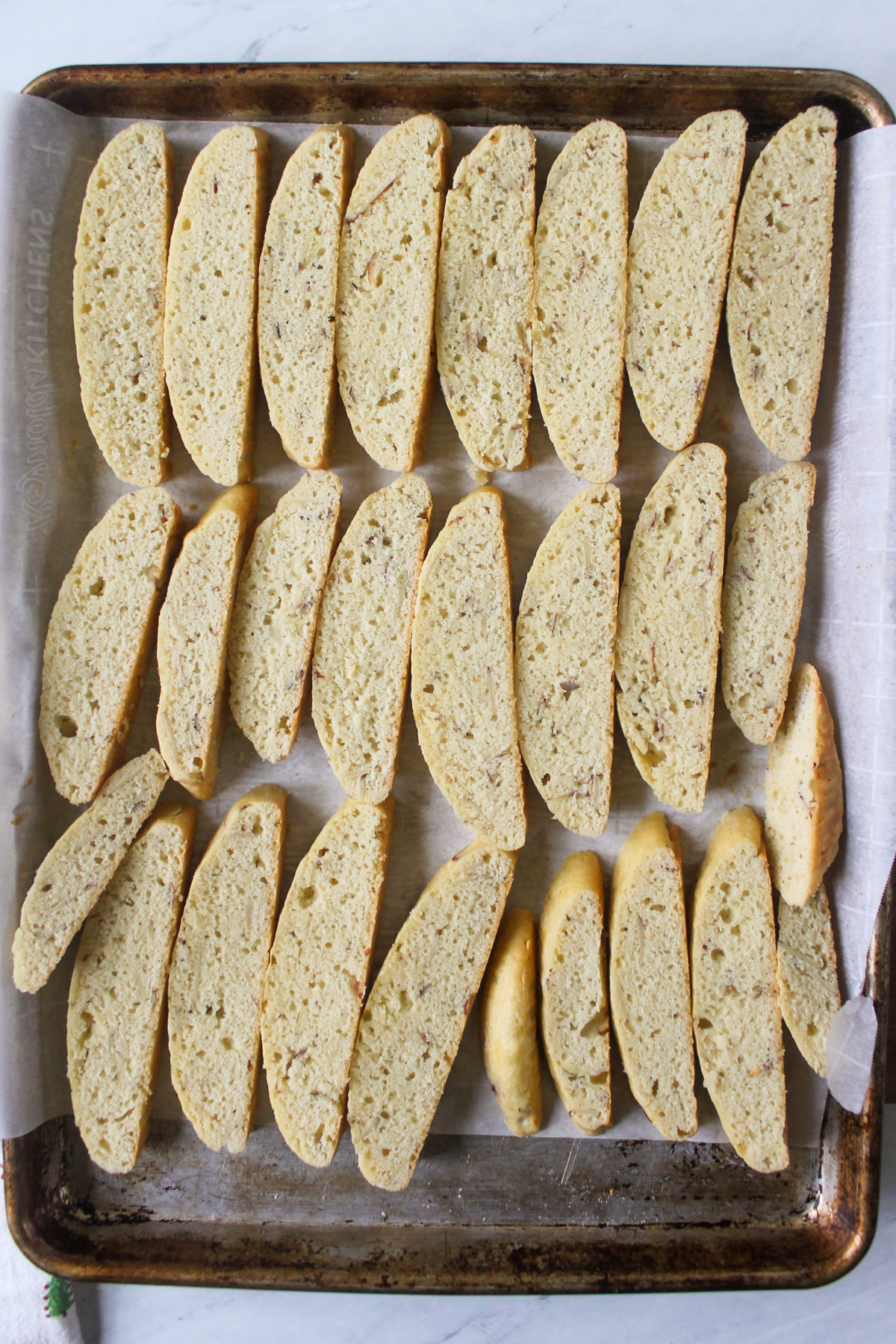 A sheet pan full of sliced biscotti cookies ready to bake.