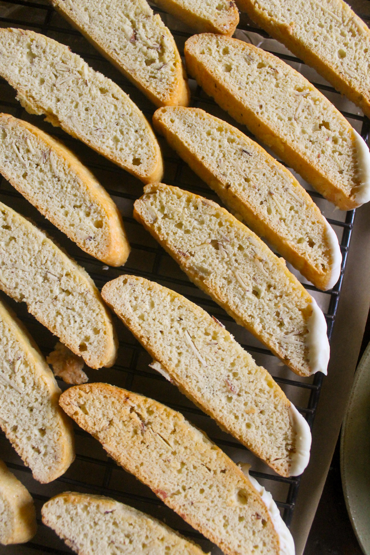 Homemade almond flour biscotti lined up on a wire rack.