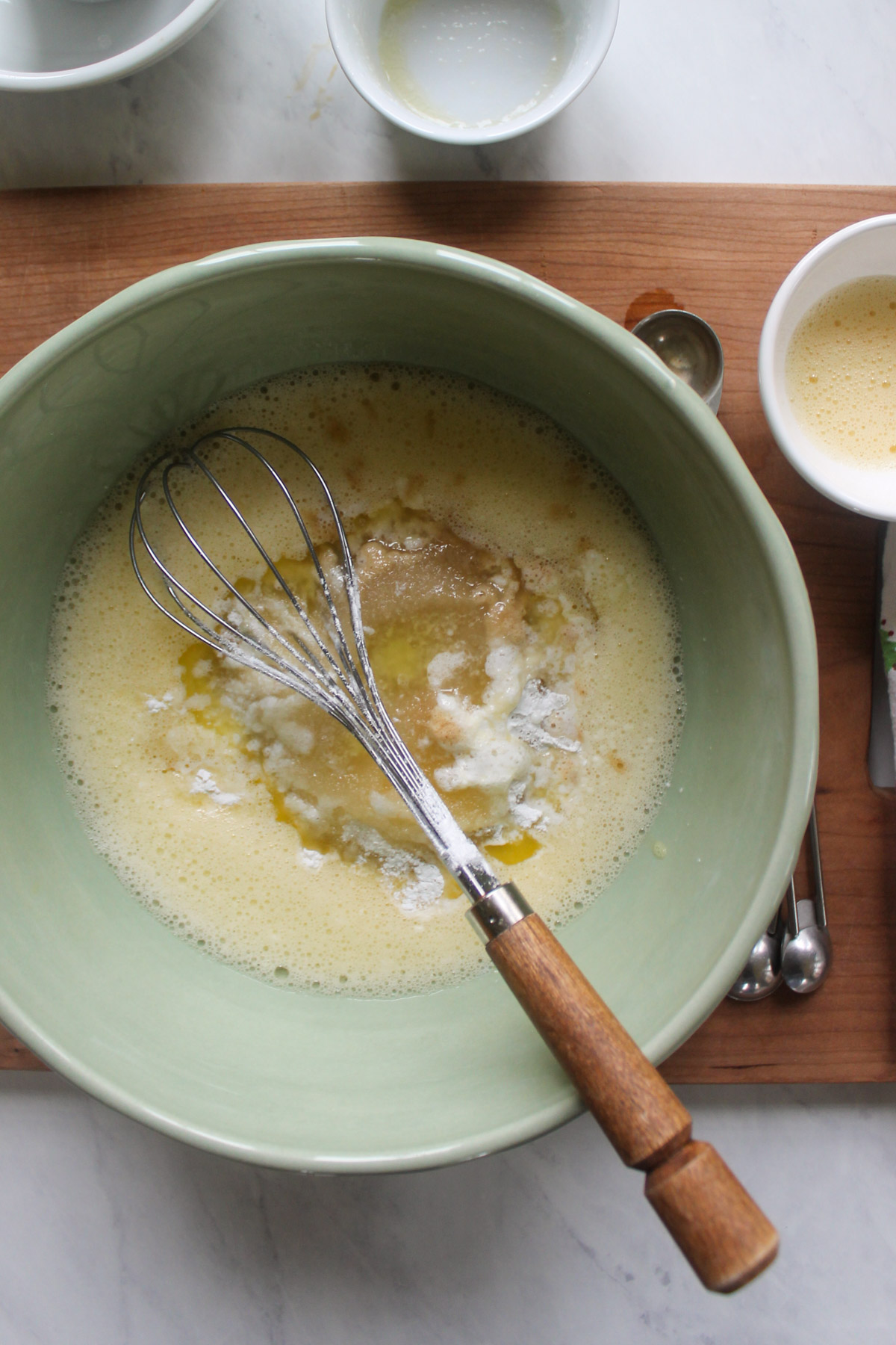 Adding ingredients to a bowl of whisked eggs.