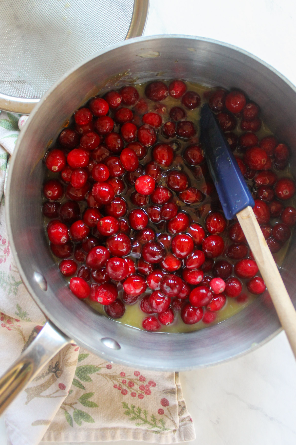 Fresh cranberries in a sauce pot with honey and orange juice.