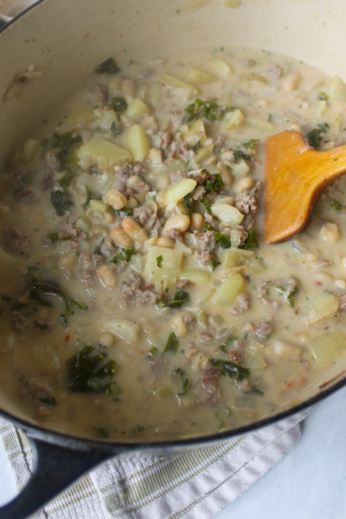 A pot of creamy sausage potato kale soup.