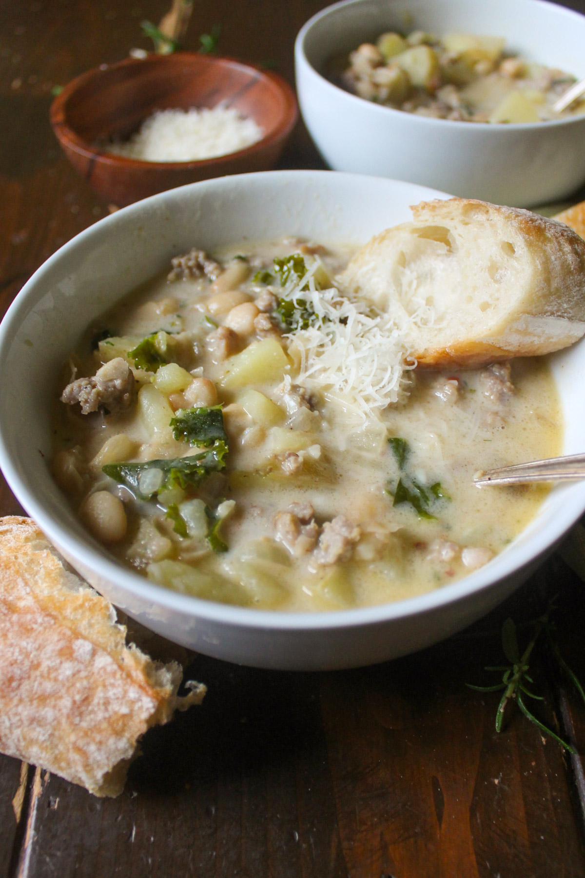 A bowl of Creamy Sausage Potato soup with Parmesan cheese.