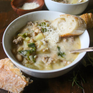 A bowl of Sausage Potato Soup with bread.