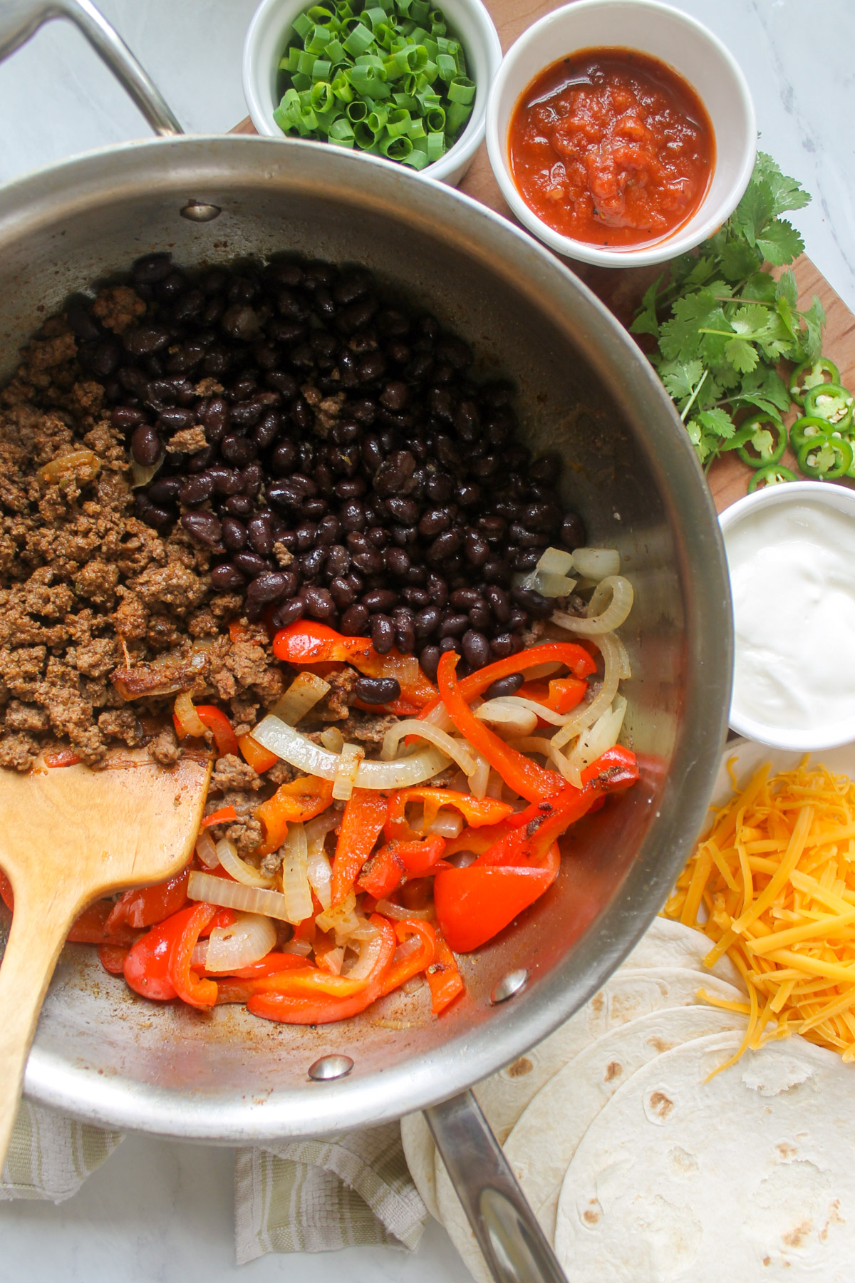 A skillet of ground beef taco meat, black beans and sautéd peppers and onions.