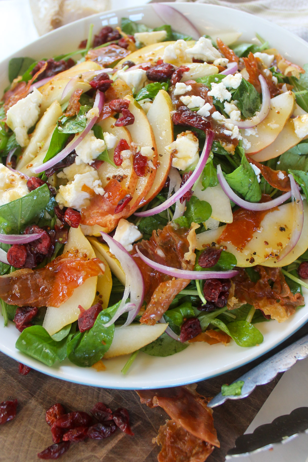 Pear Arugula Salad with crispy prosciutto, feta cheese and dried cranberries.