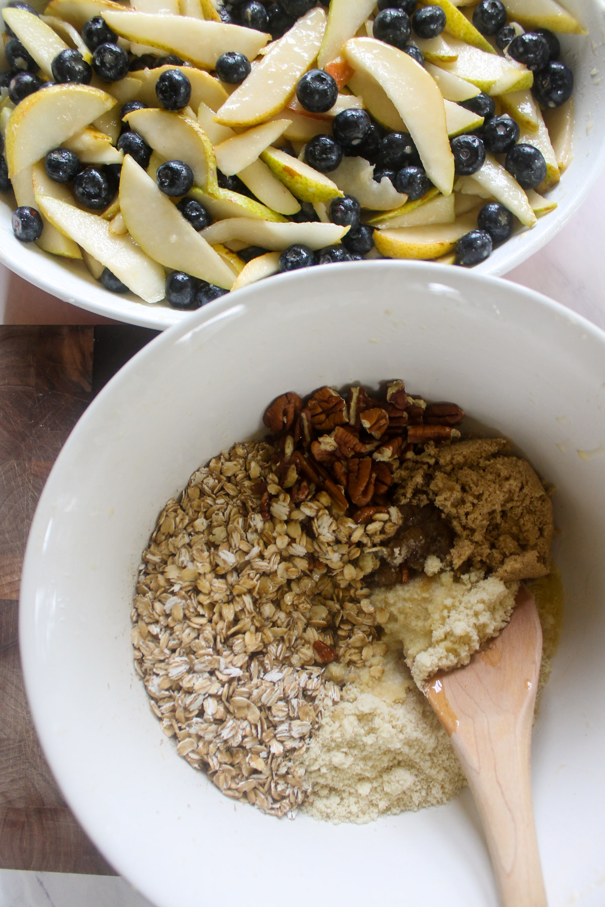 Mixing a bowl of oat pecan topping for pear blueberry crisp.