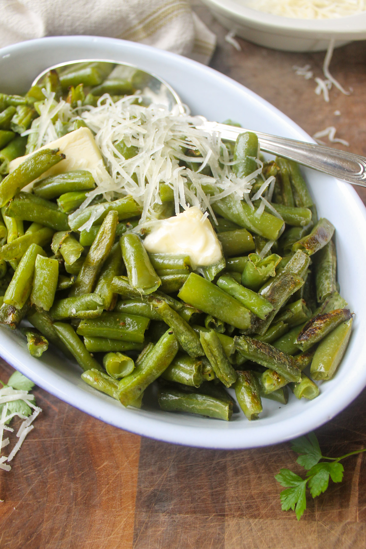 A dish of roasted frozen green beans with butter and Parmesan cheese.