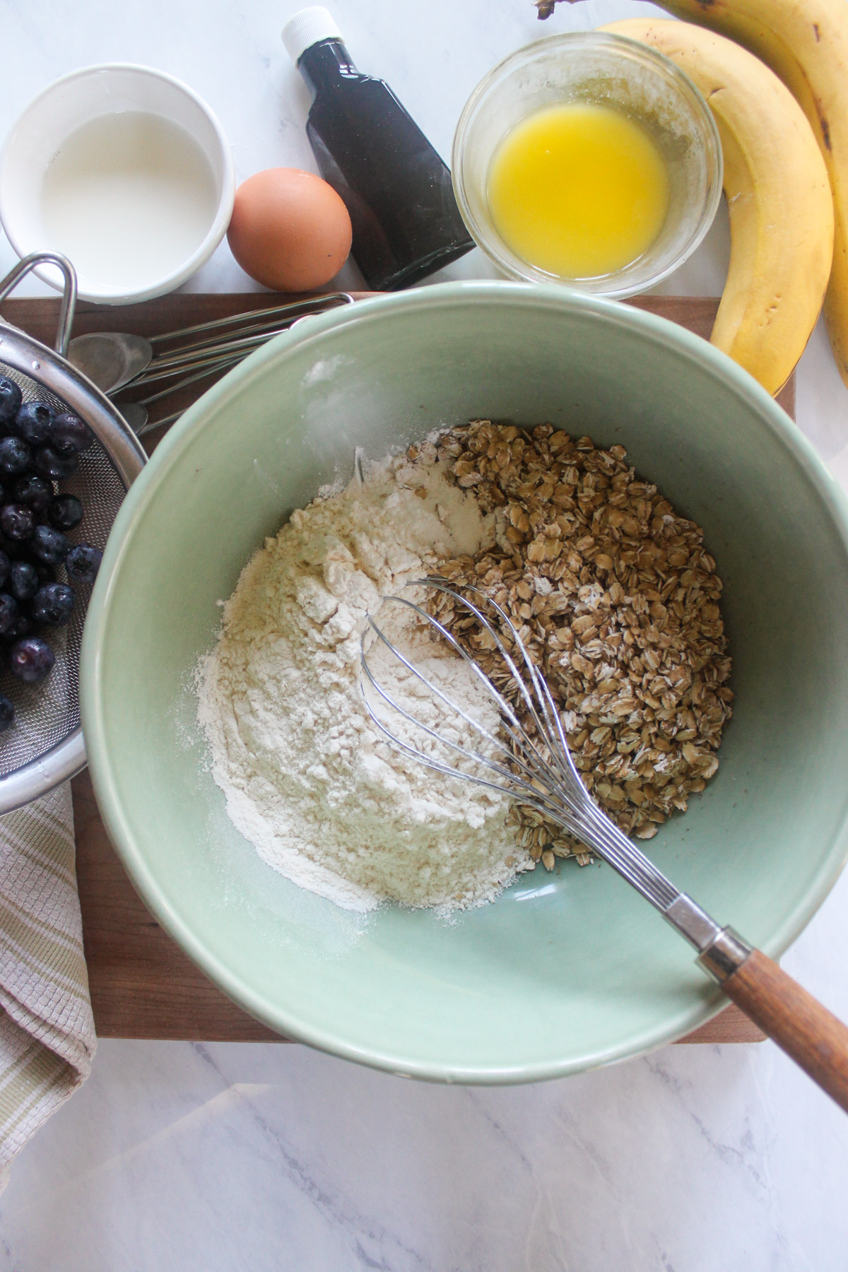 Dry muffin ingredients in a bowl with a whisk.