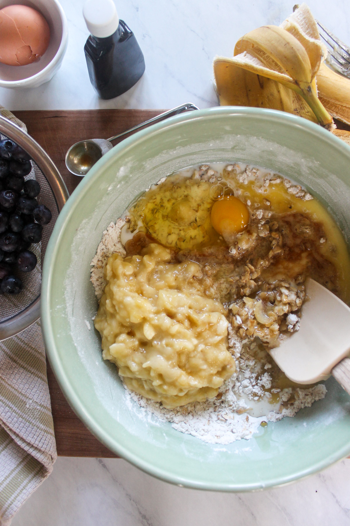 Mixing blueberry muffin batter in a bowl.