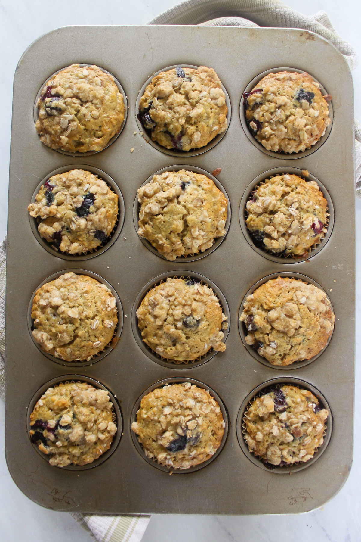 Baked blueberry banana muffins in a muffin tin.