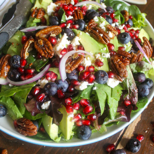 Pomegranate Blueberry Feta Salad with sliced avocado and red onion.