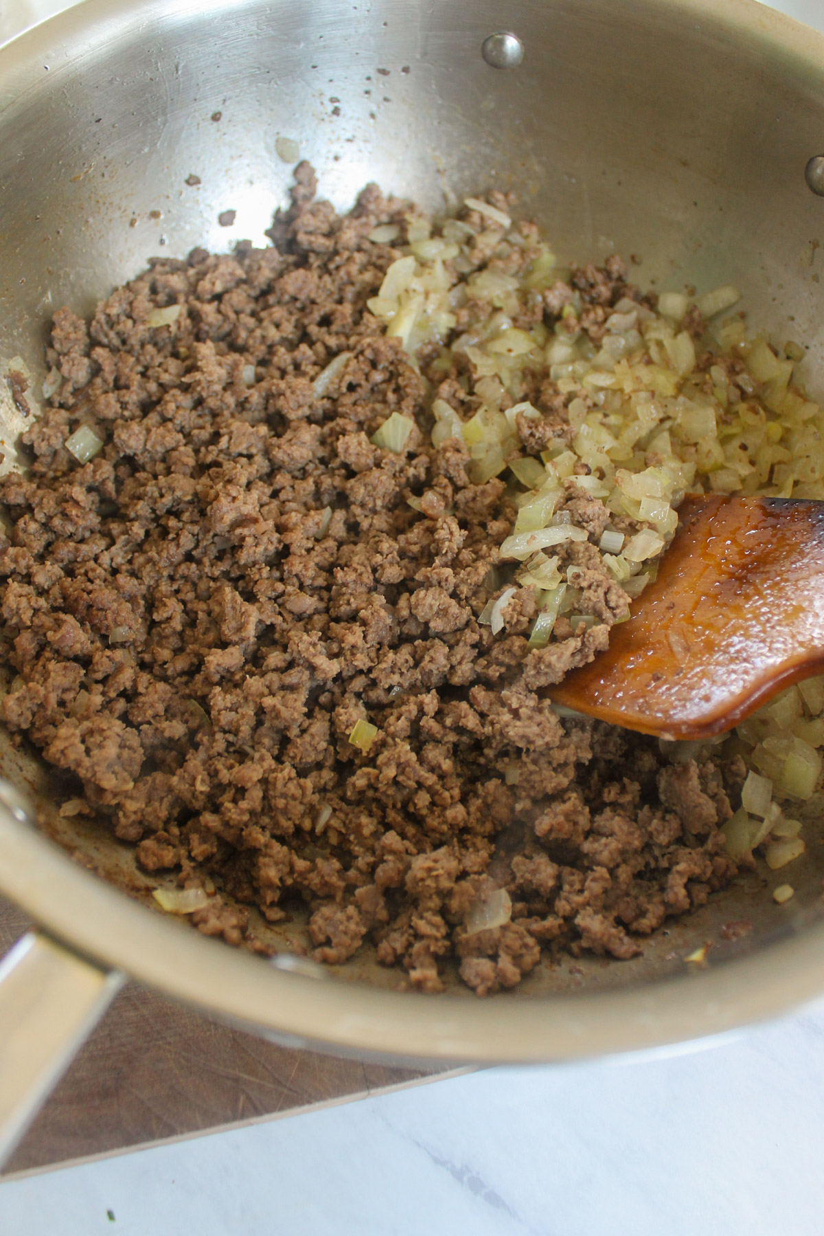 Fully browned ground beef and sauted onions in a skillet.