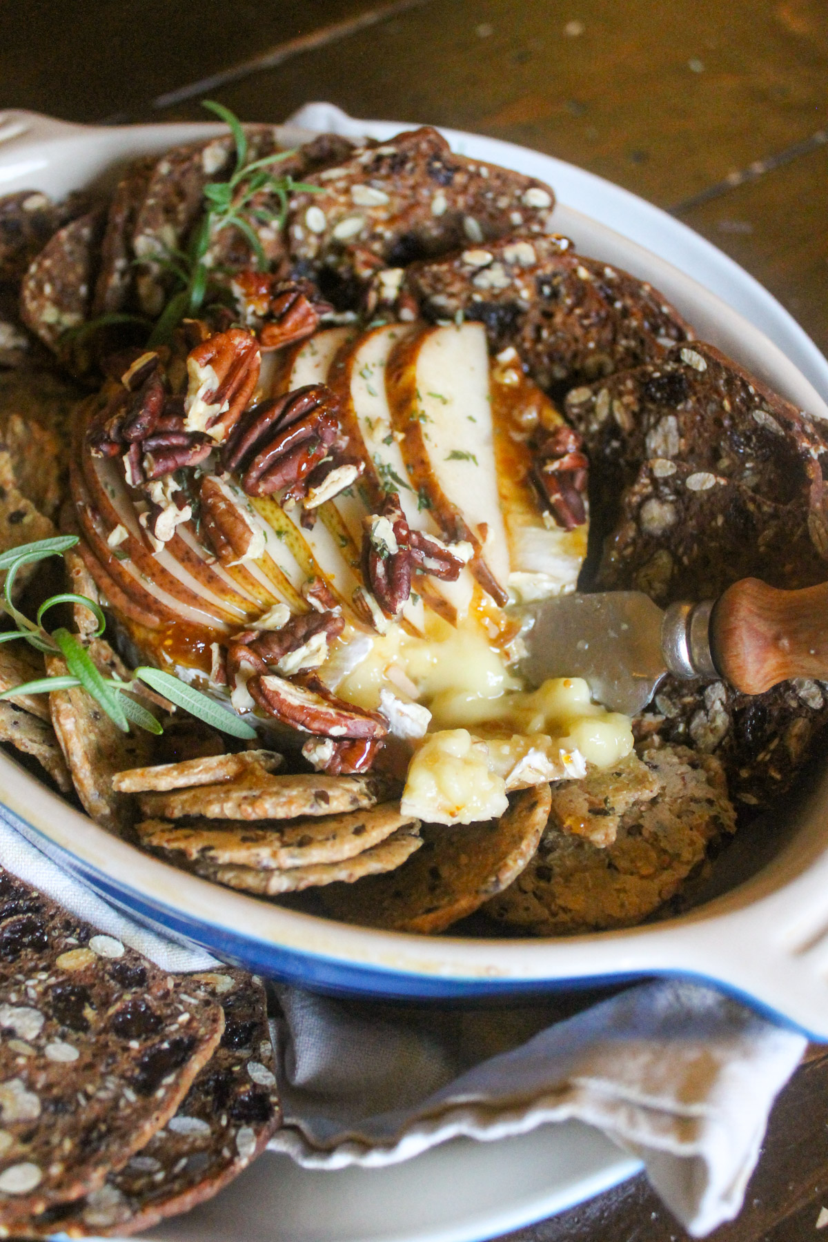 Baked brie topped with pears and honey with crackers.