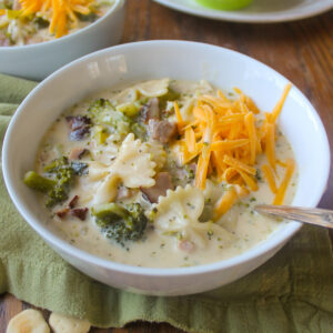 A white bowl of Broccoli Ham Soup with Cheddar Cheese.