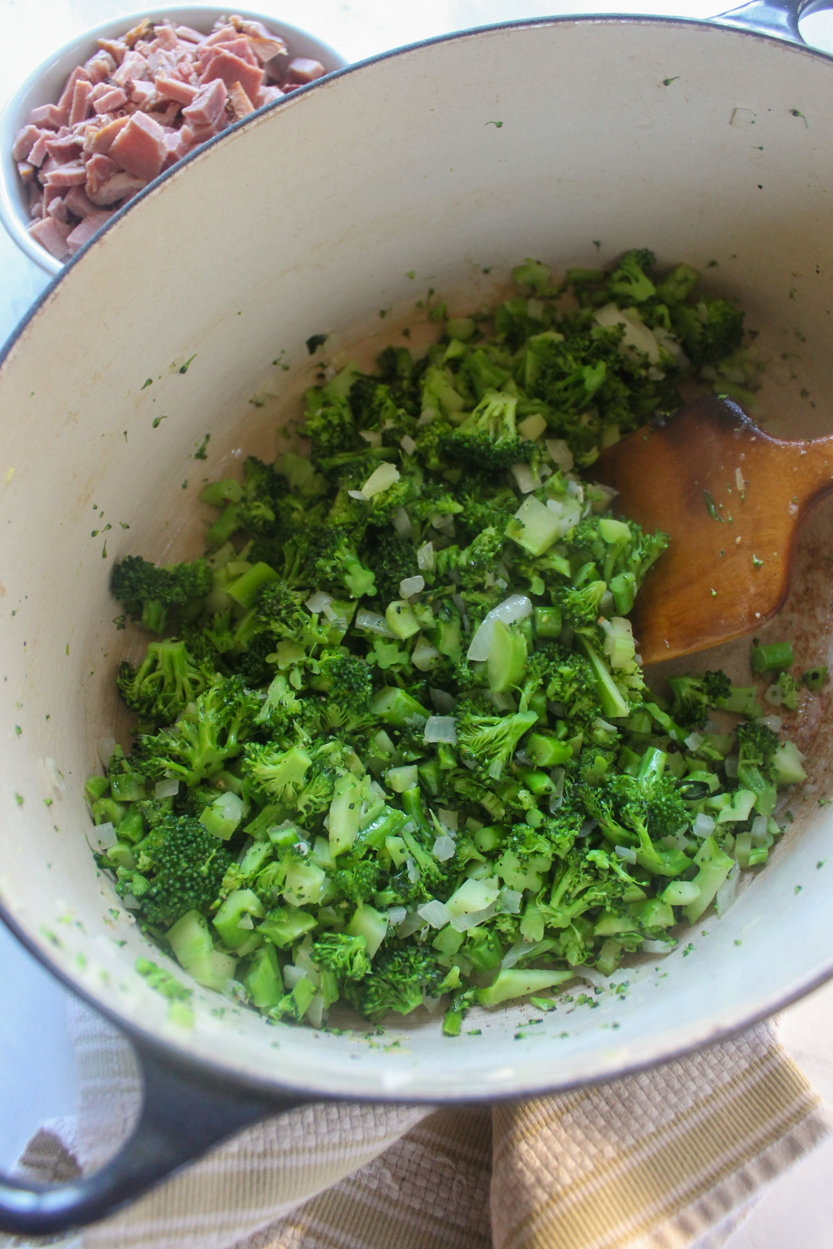 A soup pot with sautéd broccoli and onions.