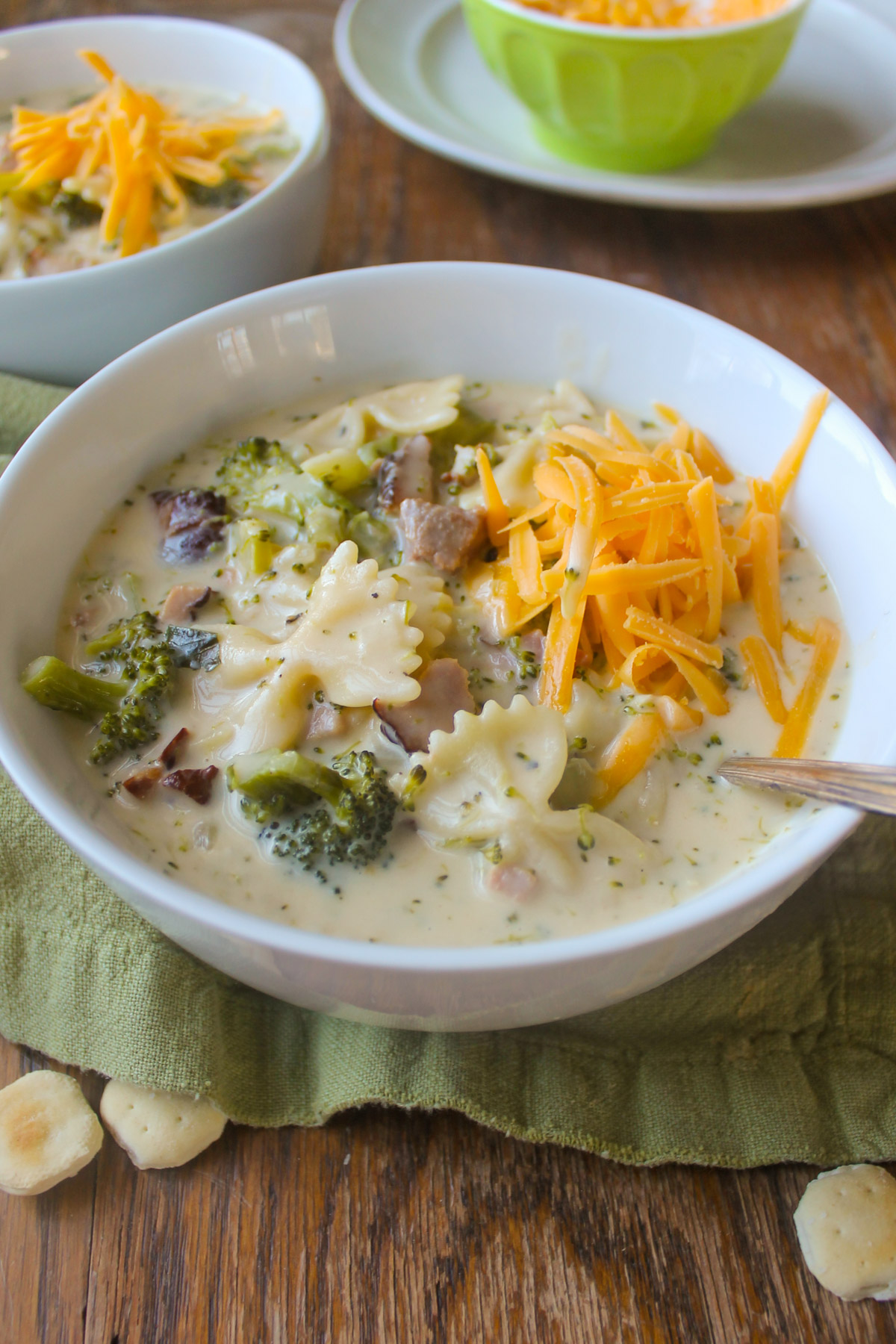 A bowl of creamy broccoli cheese ham soup.