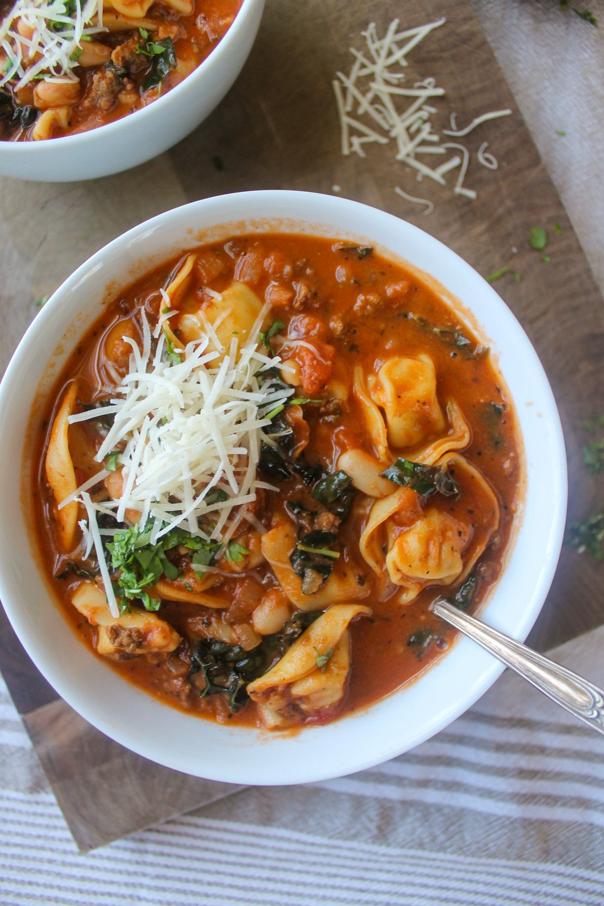 A bowl of beef and white bean tomato tortellini soup.